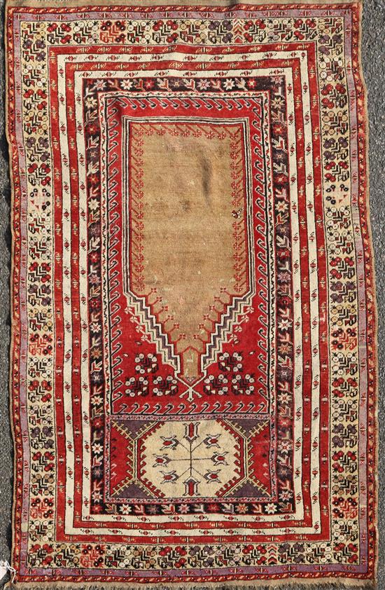 A Ghiordes red ground prayer rug, West Anatolia, 5ft 6in by 3ft 10in.